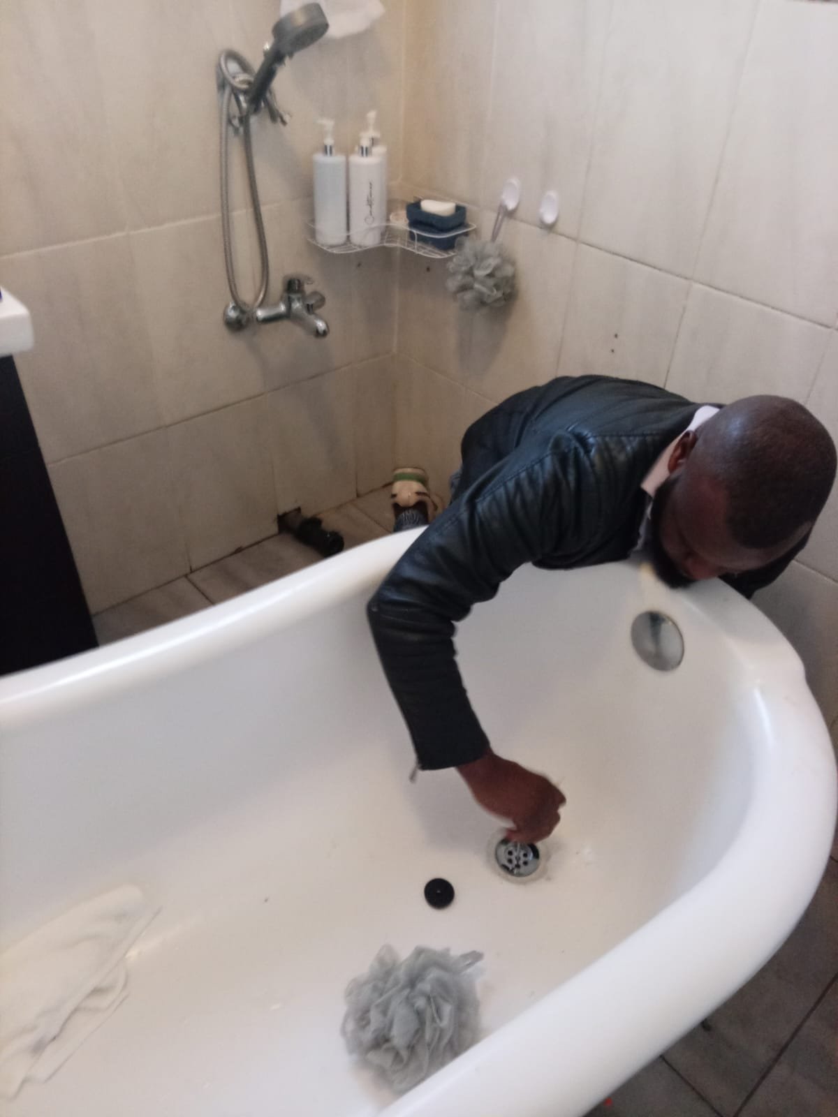 Technician repairing a bathtub drain